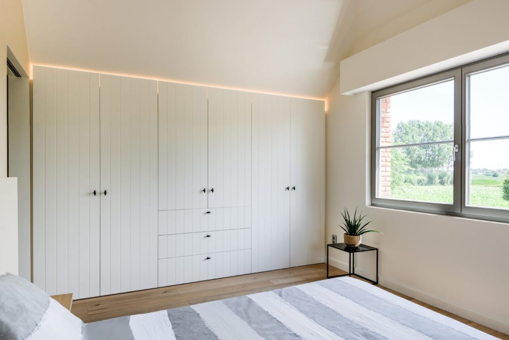 Landelijke inbouwkasten in slaapkamer onder schuine wand DMLine